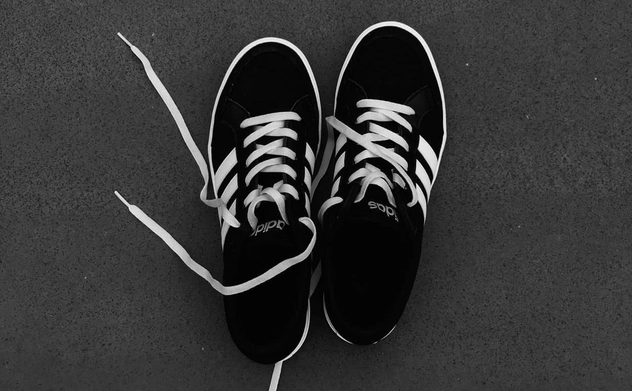 Black and white sneakers against a gray background.