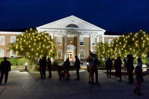 Students gathered in Coastal Carolina University campus with lit up trees.