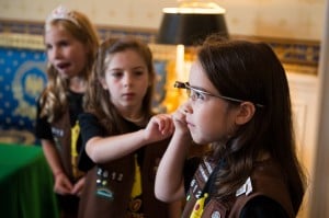 Three Girl Scouts listening intently to a STEM presentation. One is wearing GoogleGlass.