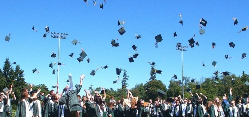 College students throwing their graduation caps in the air.