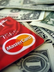 Red MasterCard with dollar bills in the background.