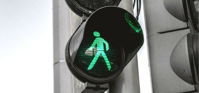 A crossing light showing a green man walking.