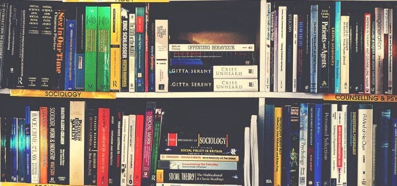 Rows of sociology books on bookshelves.