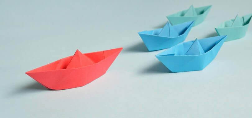 Pink, blue and green origami boats.