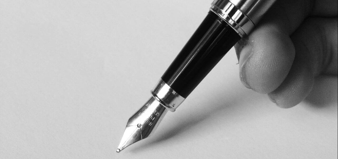 A person holding a pen against paper.