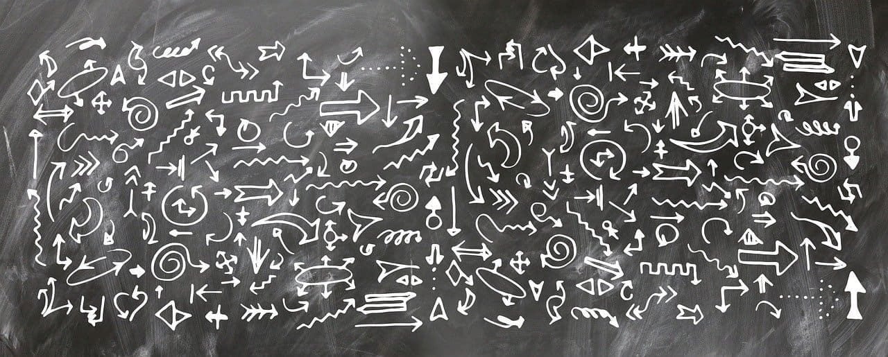 Multiple arrows drawn on a blackboard.