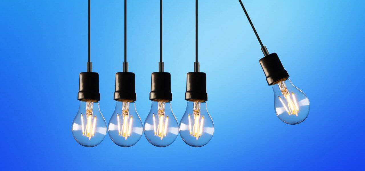 Five light bulbs with the right-most light bulb swinging.