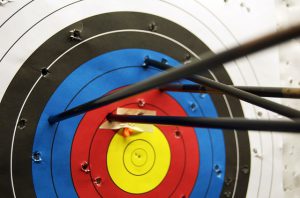 Archery target four arrows, each outside the bullseye ring.