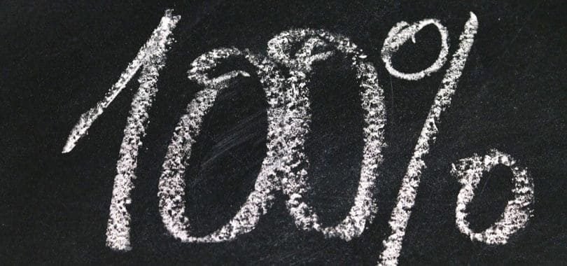 "100%" written on a chalkboard.