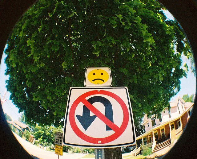No U Turn signage with sad face above it.