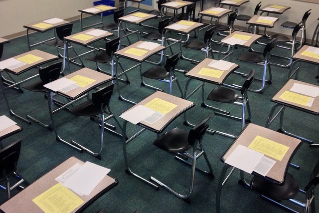 Classroom chairs with test papers on the desk.