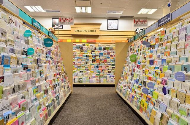 A lot of greeting cards on shelves at book store.