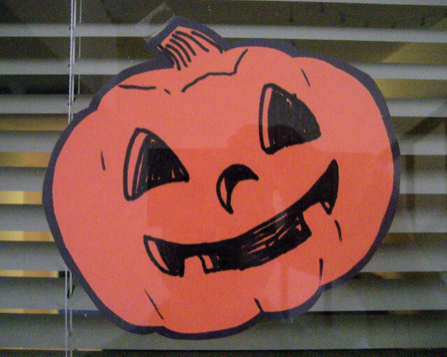 Paper Halloween pumpkin pasted in window glass.