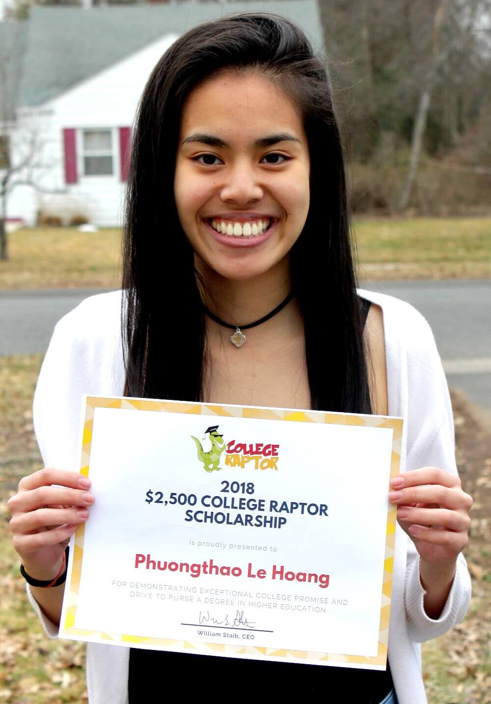 A young female student smiling while holding a $2500 College Raptor Scholarship certificate.