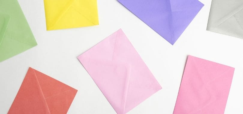 Various colorful envelopes scattered on a white surface.