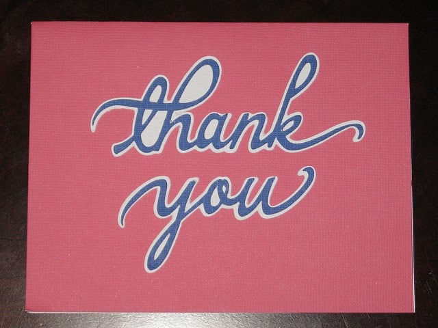 Thank you cursive font against pink background.
