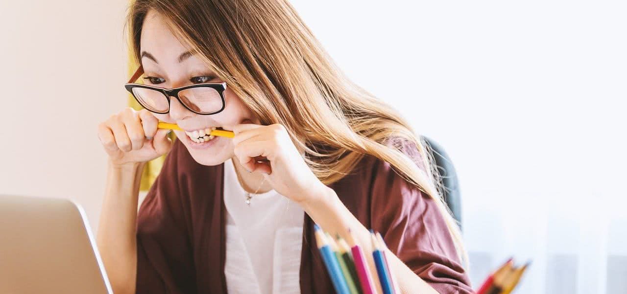 A student biting onto a pencil looking frustrated.