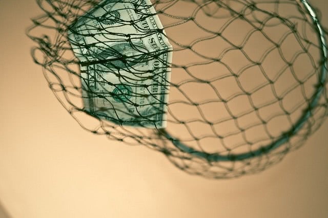 A one-dollar bill stuck inside a green fish net.