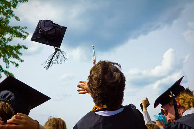 Student tossing his graduation cap in the air.