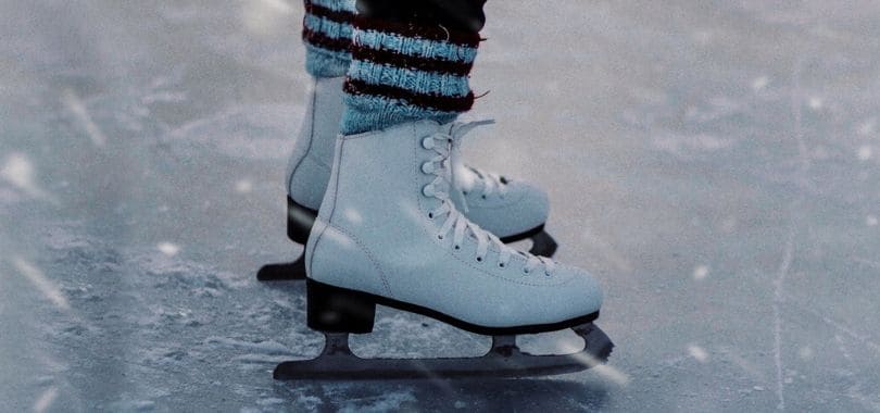 A close-up shot of an ice skater's skates.