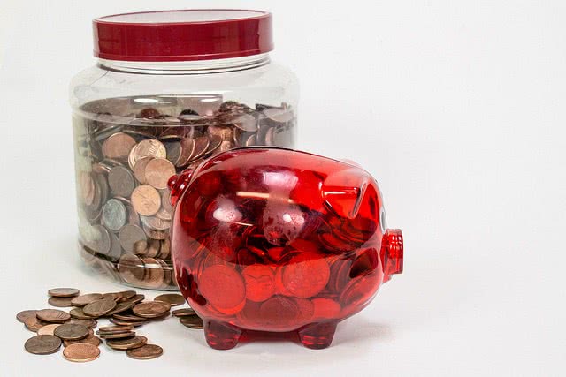 A piggy bank and jar full of coins inside.