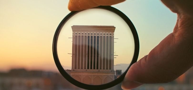 Magnifying glass over college building.